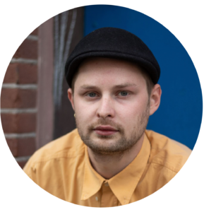 Foto van een glimlachende jongen met een geel shirt en een petje op